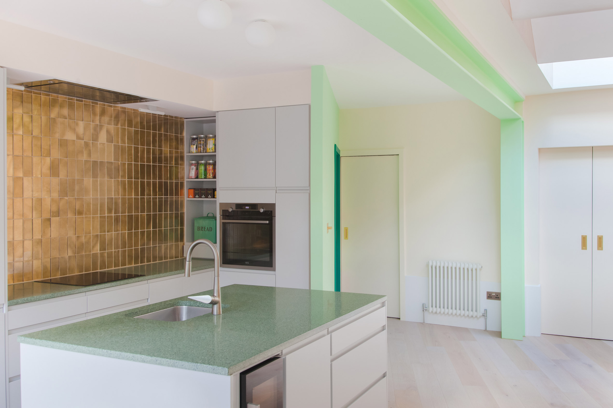 White kitchen with green-painted structure in London