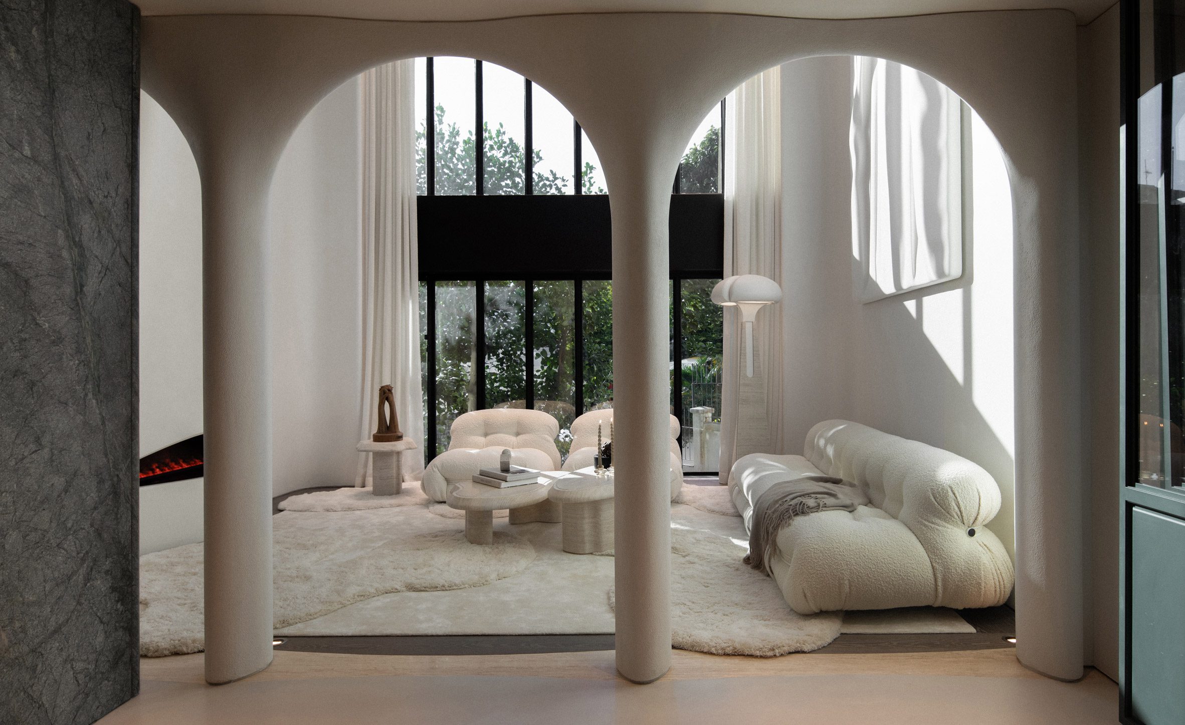 An image showing a contemporary, white living room that can be seen through curved archways.
