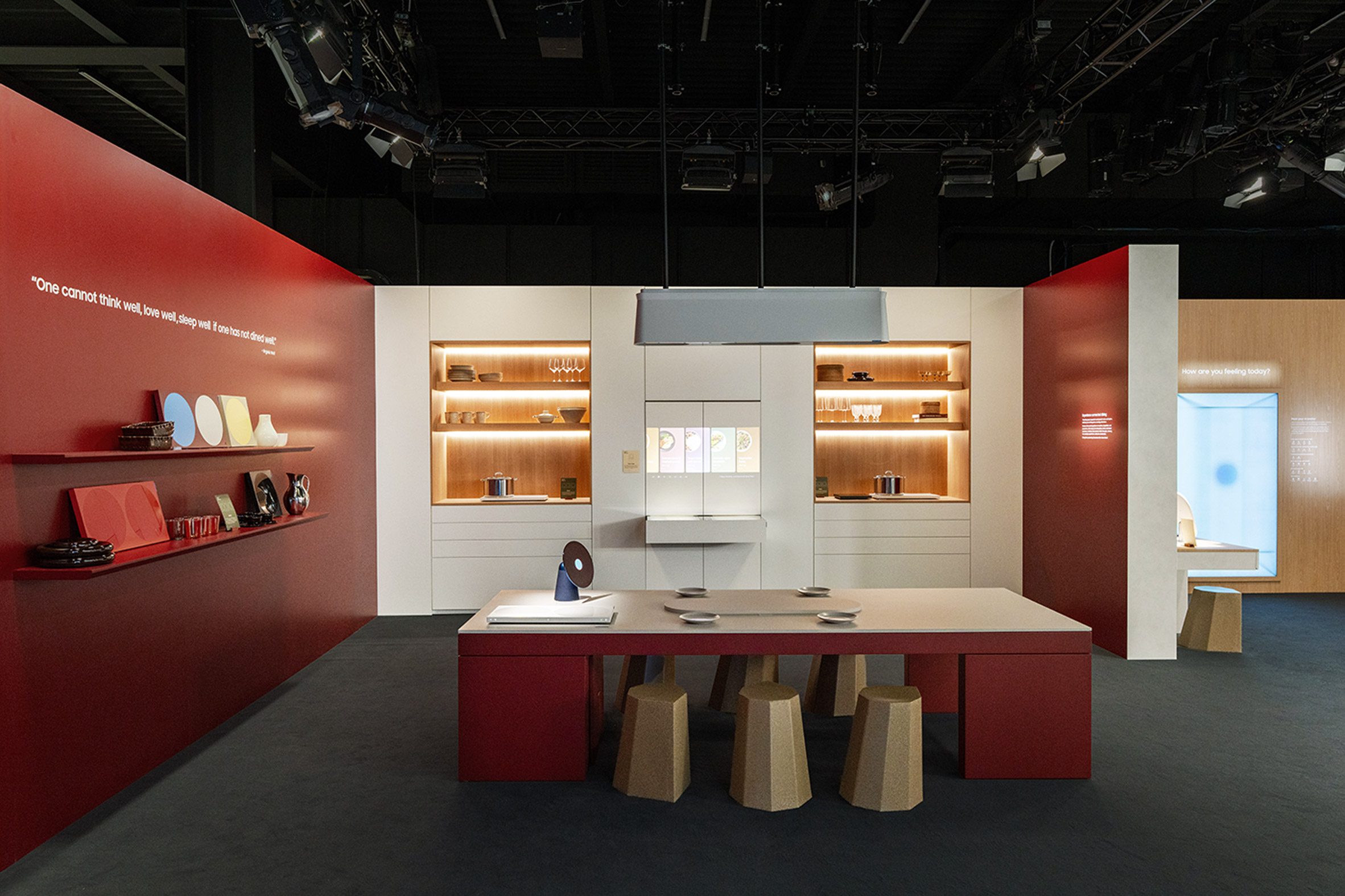 Red shelving unit displaying small products and objects arranged in a gallery-like exhibition setting