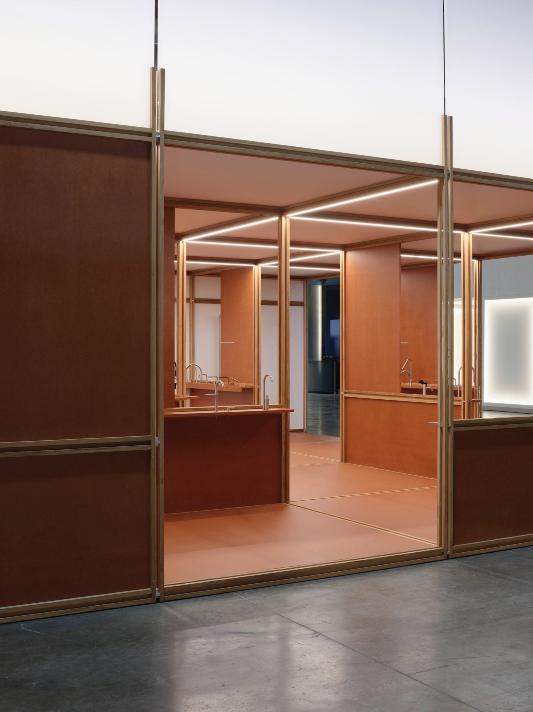 Photo looking into the QuadroDesign booth at Salone del Mobile 2026 from outside, showing the open framework partly closed with partitions
