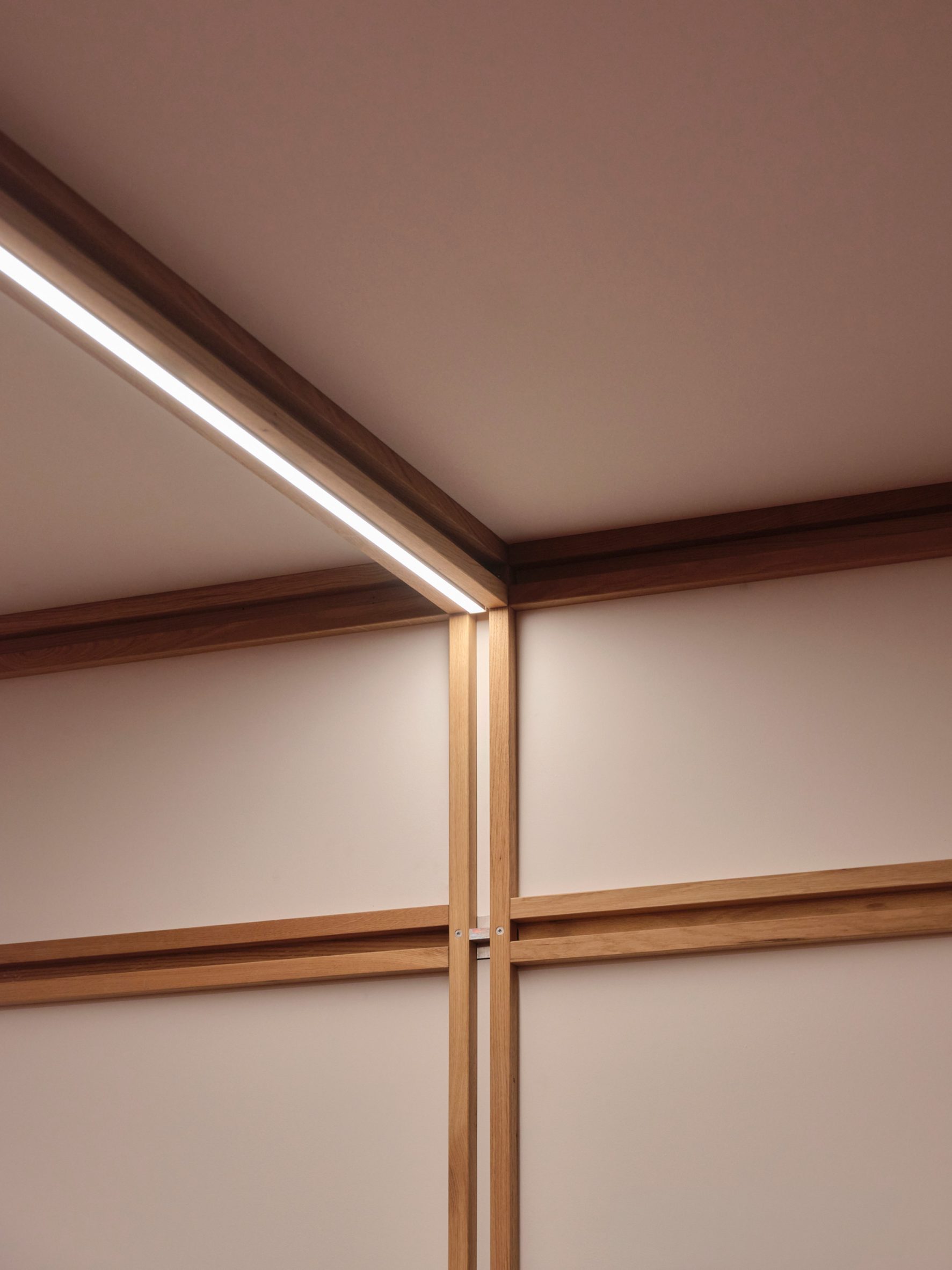 Close-up photo of the framework joining at the ceiling of the QuadroDesign booth at Salone 2026, with a lighting strip embedded in a cavity of the ceiling beam
