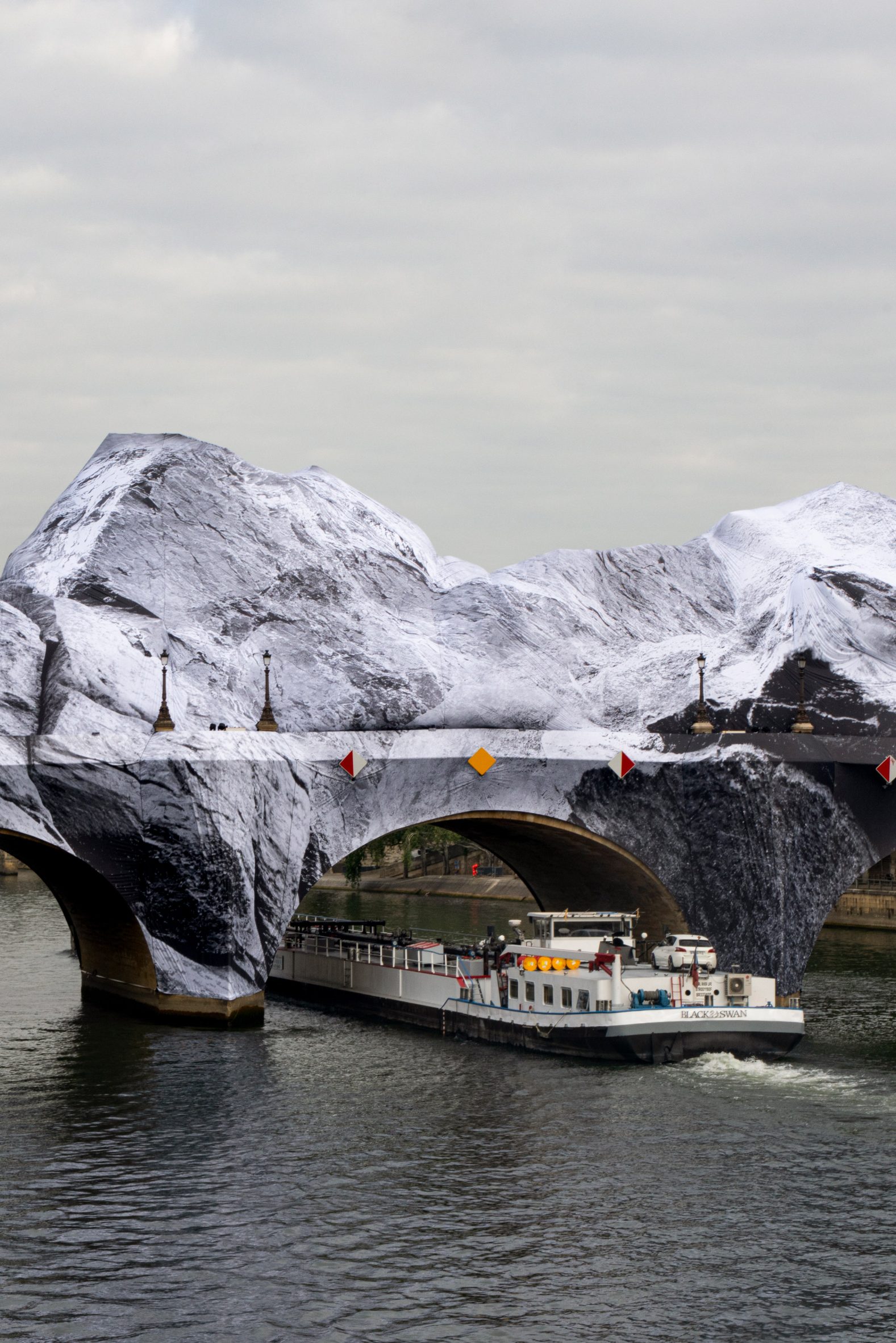 Boat passing beneath La Caverne du Pont Neuf by JR
