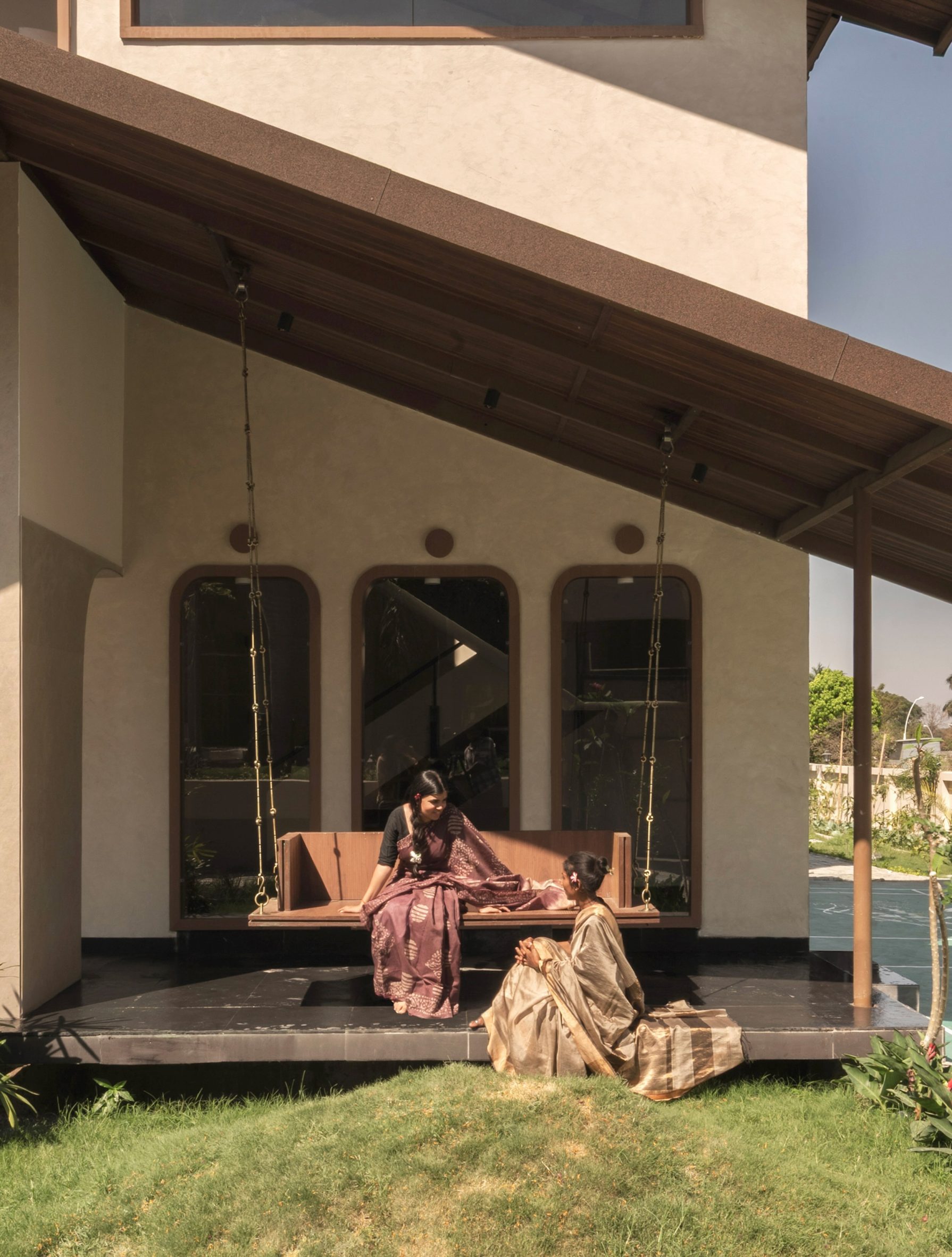 People sitting outside Indian home by Otlo Studio