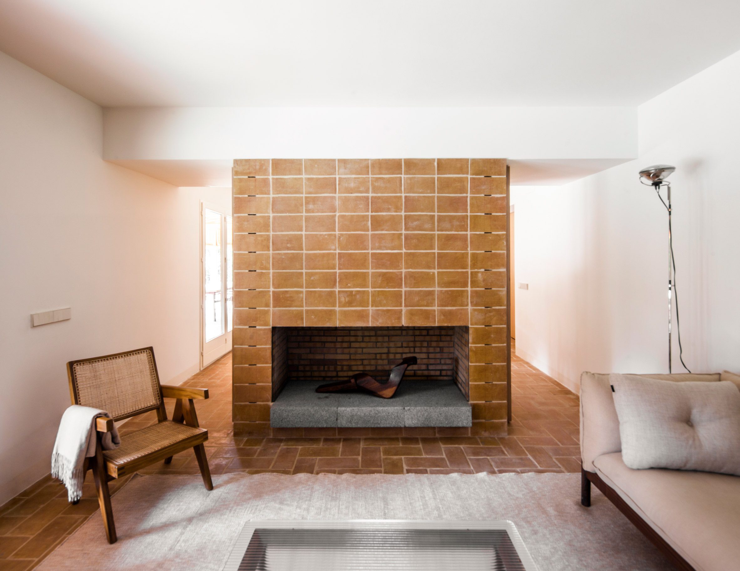 Living room with terracotta-tiled fireplace and brick flooring