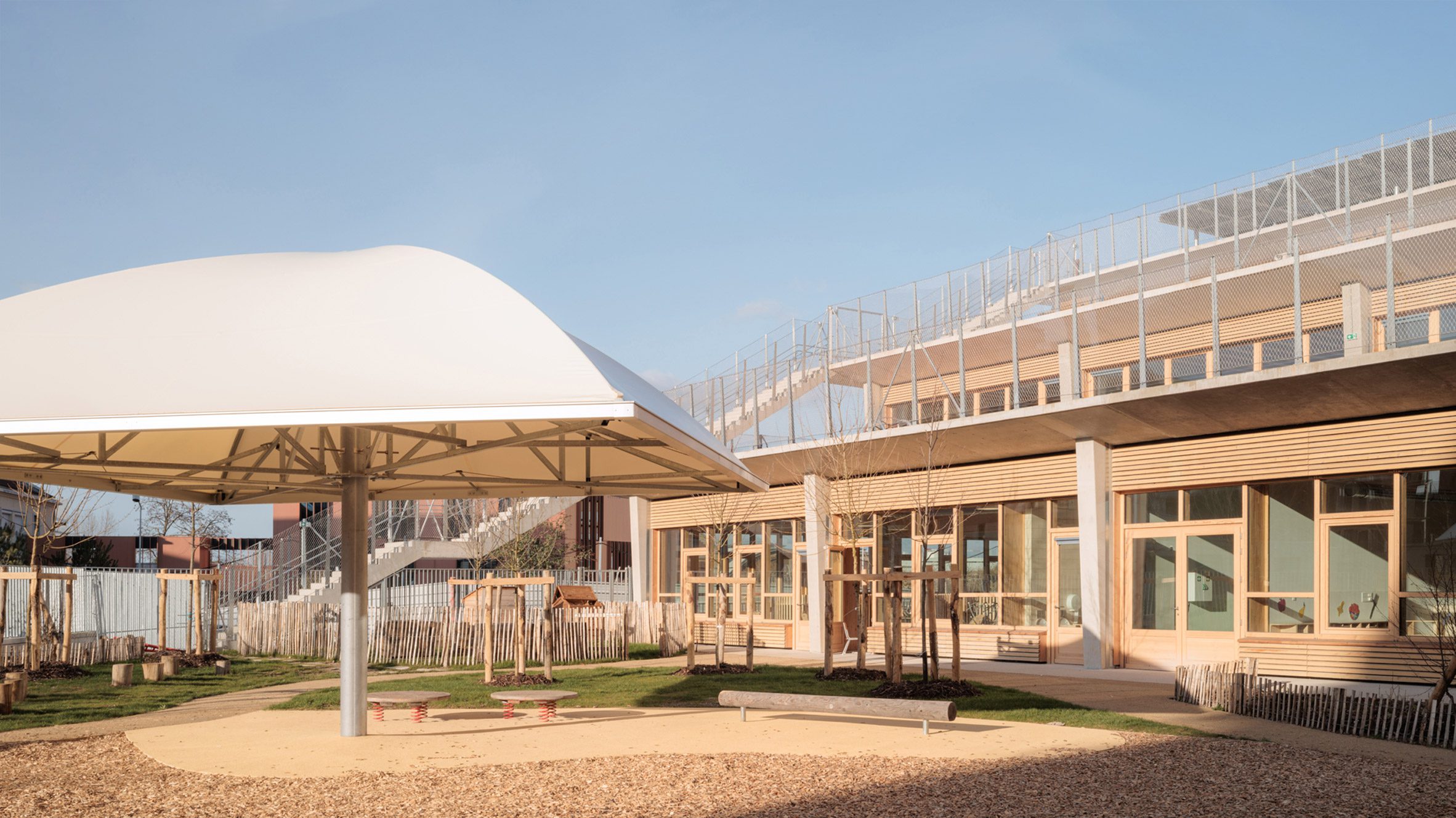 Playground and courtyard space beneath the stepped school building